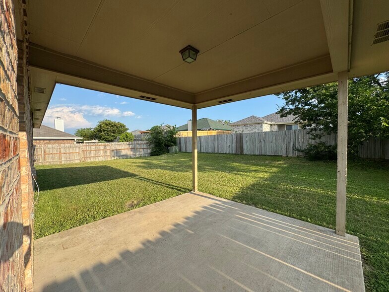 Concrete slab and roof cover shield you from Texas sun while the expansive, fenced lawn invites play - 2806 Maria Dr
