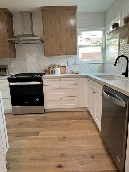 Kitchen with brand new stainless steel appliances to the left and living room to the right - 5950 Simpson Ave