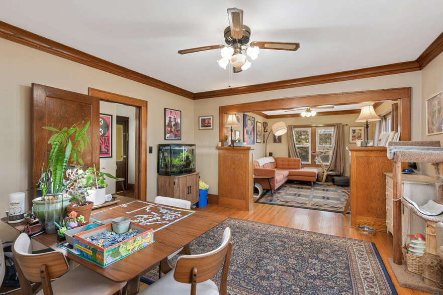 Expansive living room and dining room with hardwood floors, trim and ceiling fans - 616 37th Ave NE