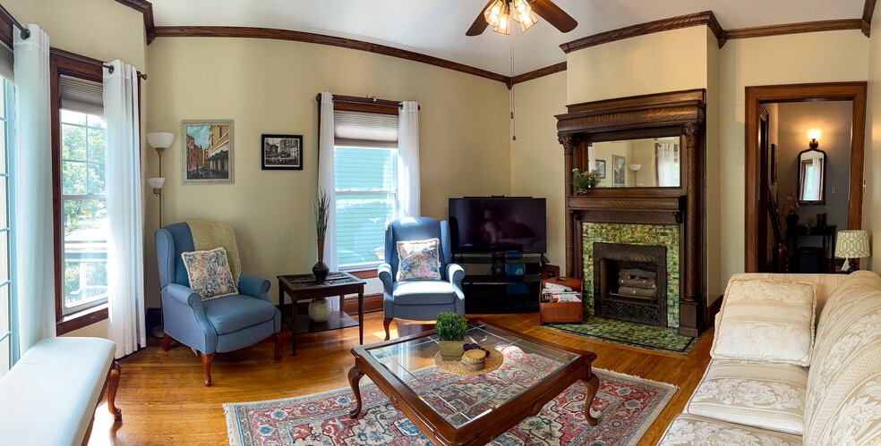 [Living Room] Spacious room with large windows, provides a beautiful view of a tree-lined street. - 103 Lancaster Ave