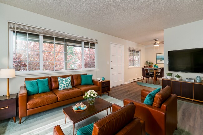 Explore this cozy living space featuring modern furnishings and abundant natural light. - University Crossing Apartments