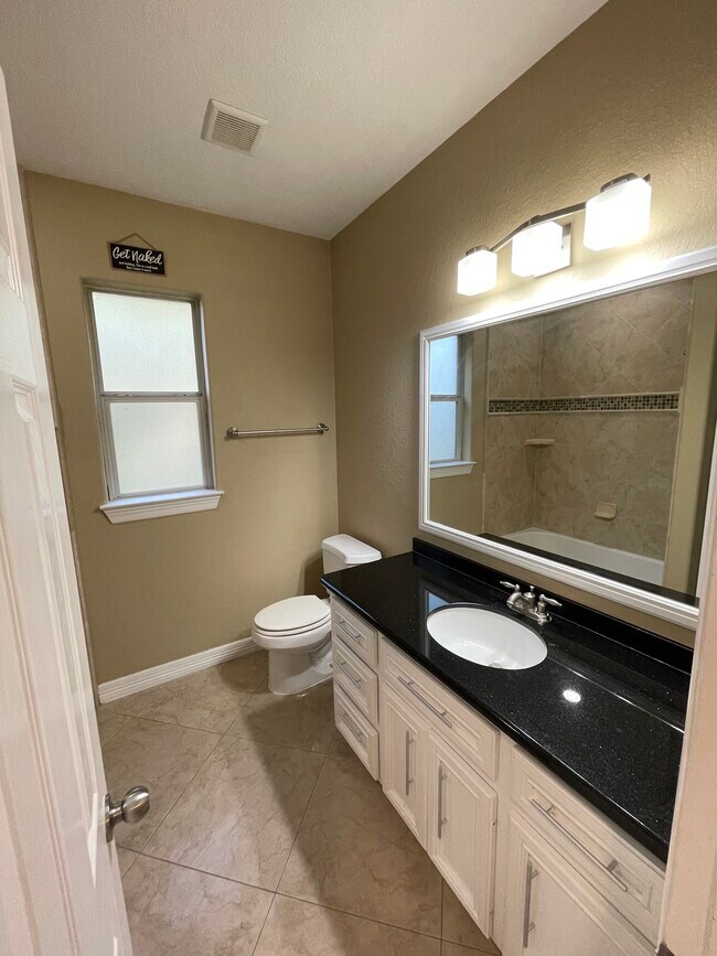 2nd hallway bathroom With granite countertops black and gold flakes - 600 River Bend Dr