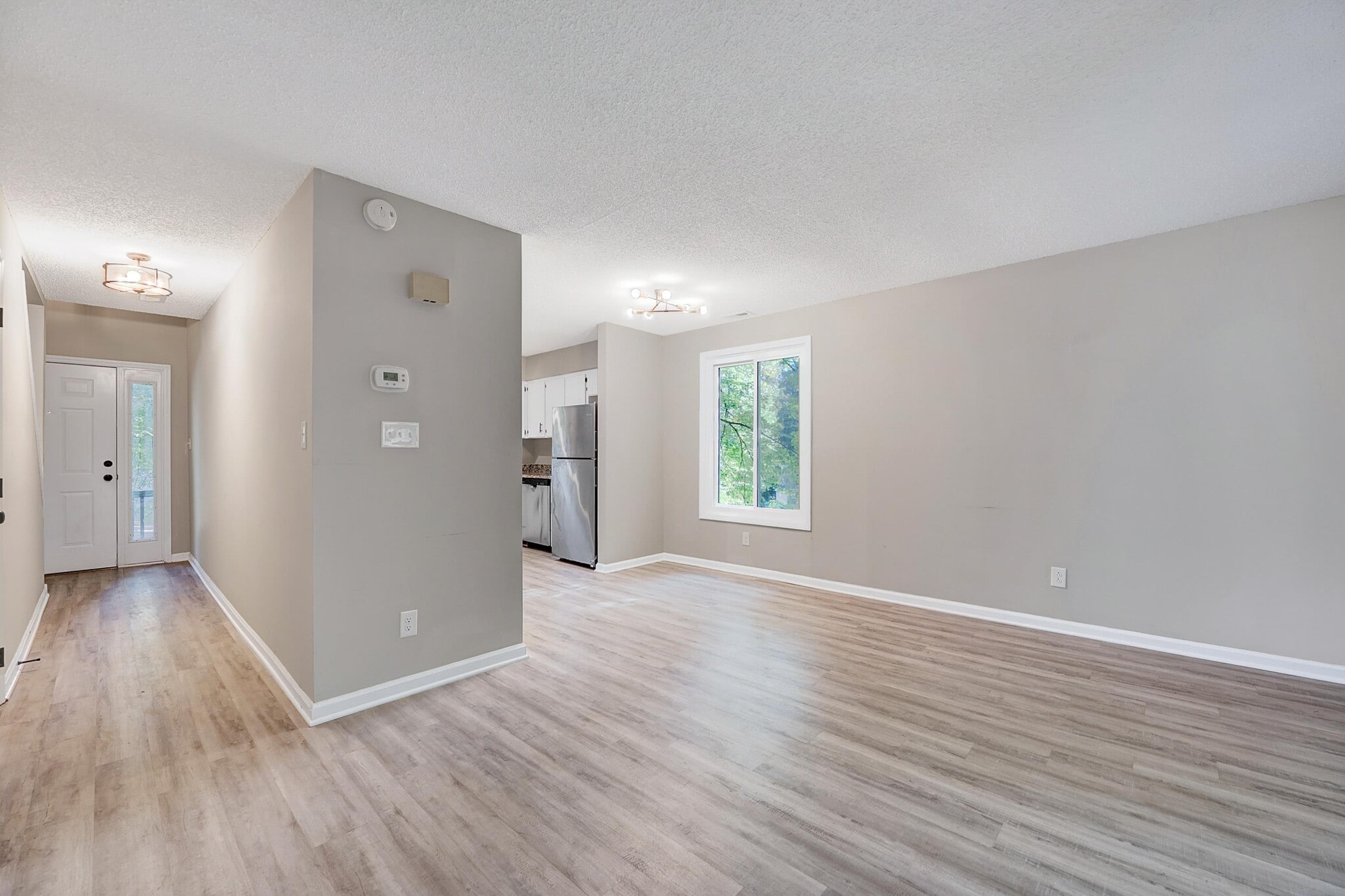 Showing the front door on the left and then the open living/kitchen - 4115 Arckelton Dr