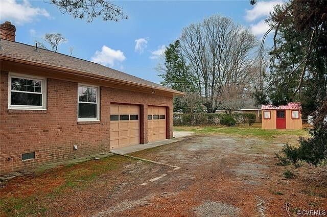 side of house with garage doors - 8208 Chamberlayne Rd