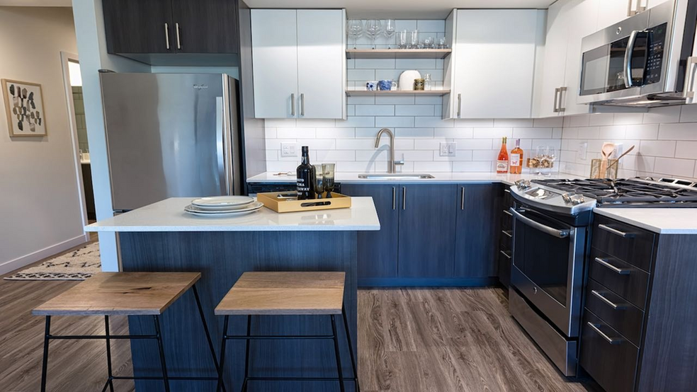 Our kitchens feature high-end finishes including stainless steel appliances and quartz countertops - Modera South Lake Union