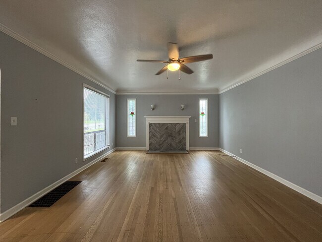 Building Photo - Three-Bedroom Home with Updated Kitchen & Vaulted Ceilings, large open basement, Hardwood floors