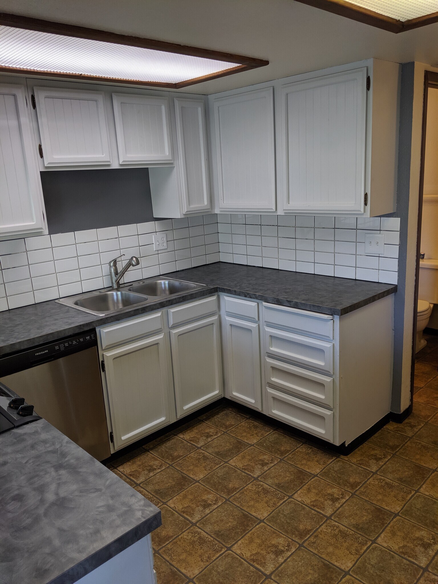 Kitchen with new stainless steel dish washer, flat top stove and fridge. - 2115 Pleasanton St