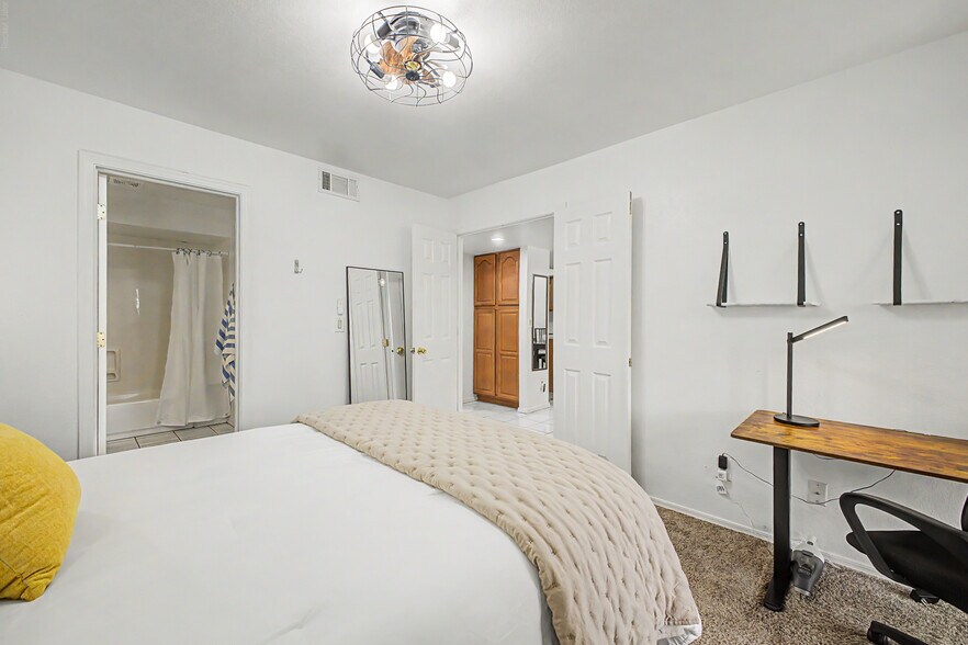 1st floor primary suite includes bathroom, patio access, sit/stand desk, & comfortable queen bed sle - 819 N College Ave