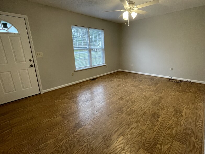 The living area features double windows, ceiling fan, and laminate flooring. - 4684 Coltsfoot Rd