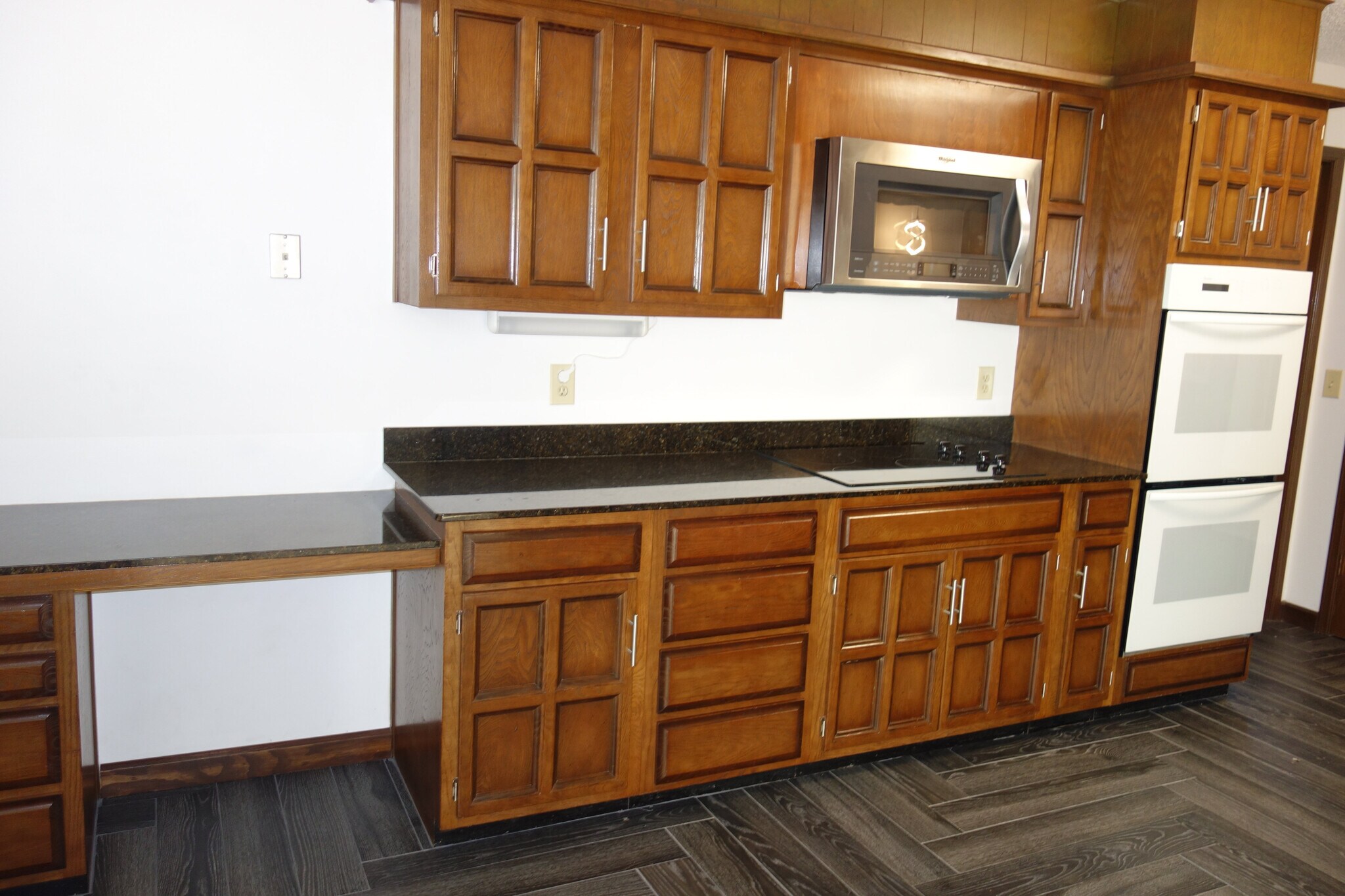other side of kitchen with desk area on left, smooth cooktop, double ovens, and microwave - 3324 E 73rd St