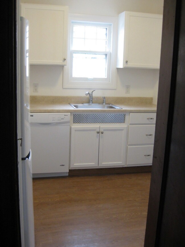 Kitchen showing fridge, dishwasher and sink - Kenmore Estates Apartments