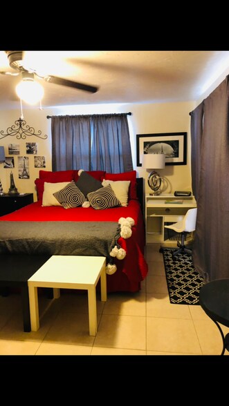 King size bed in the bedroom with a desk - 5703 Murdock Ave