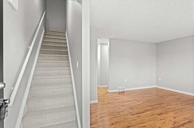 Step into elegance with this airy apartment, showcasing a welcoming staircase and open living space. - 5580 West 4th Avenue Townhomes