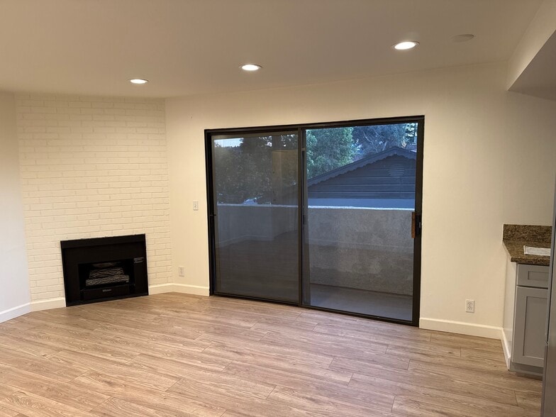 Living room with faux fire place & balcony - 10330 Riverside Dr