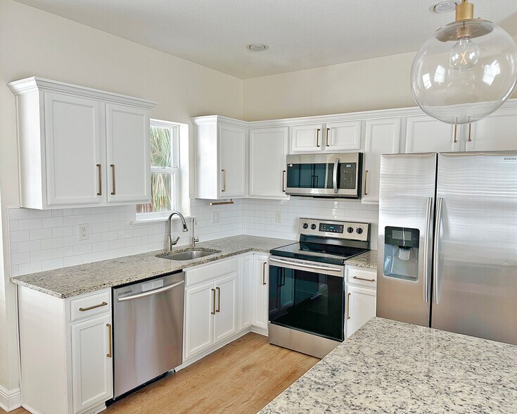 Stylish kitchen island with granite countertops, pendant lighting perfect for cooking. - 1736 W Walnut St