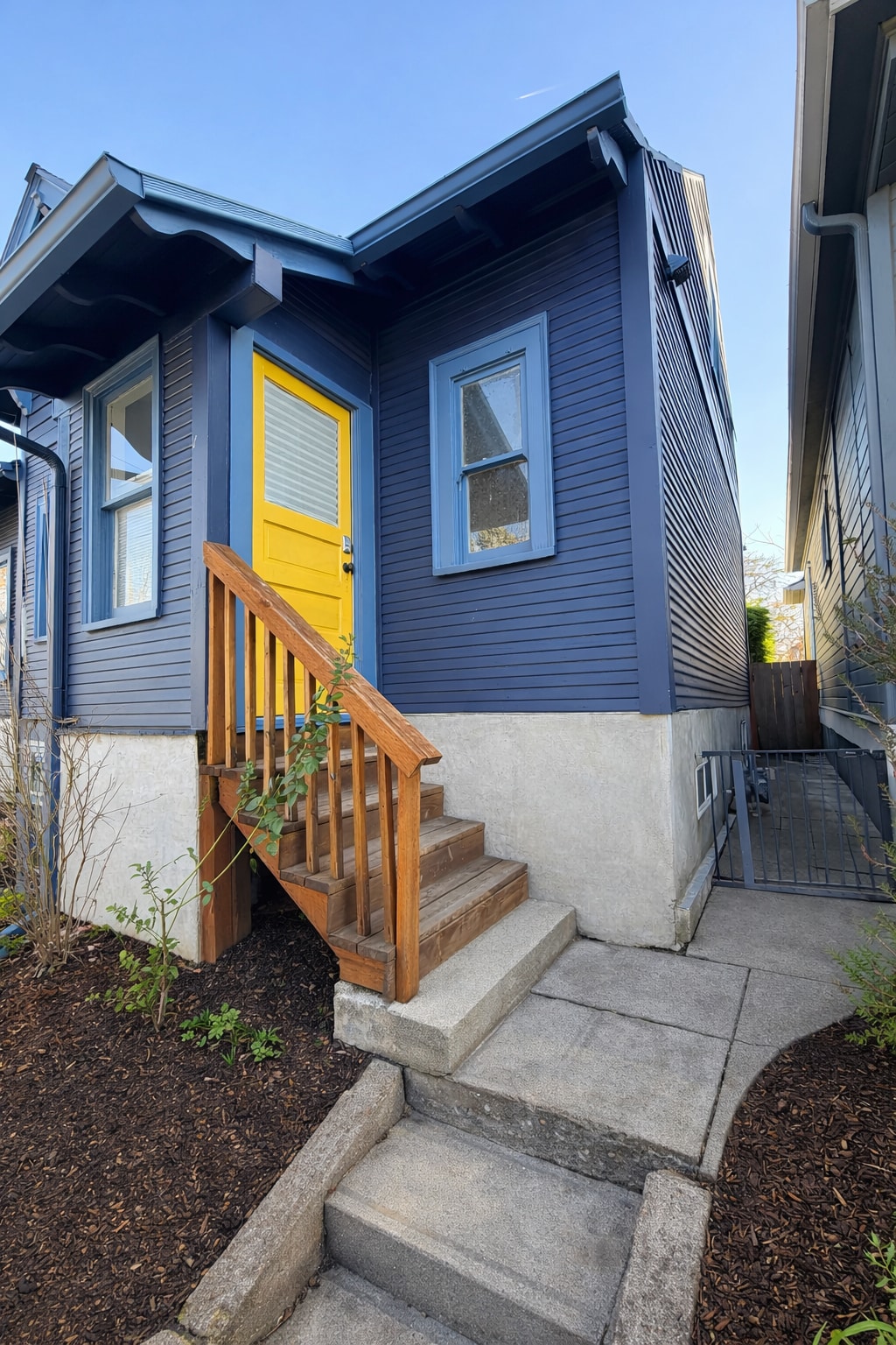 Private back entry with a cheerful yellow door. A little pop of sunshine every time you come home. - 604 NE Shaver St