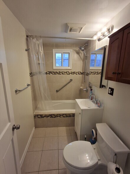 Tiled bathroom includes brand-new sink/vanity and new light fixture. - 13 Mulberry St
