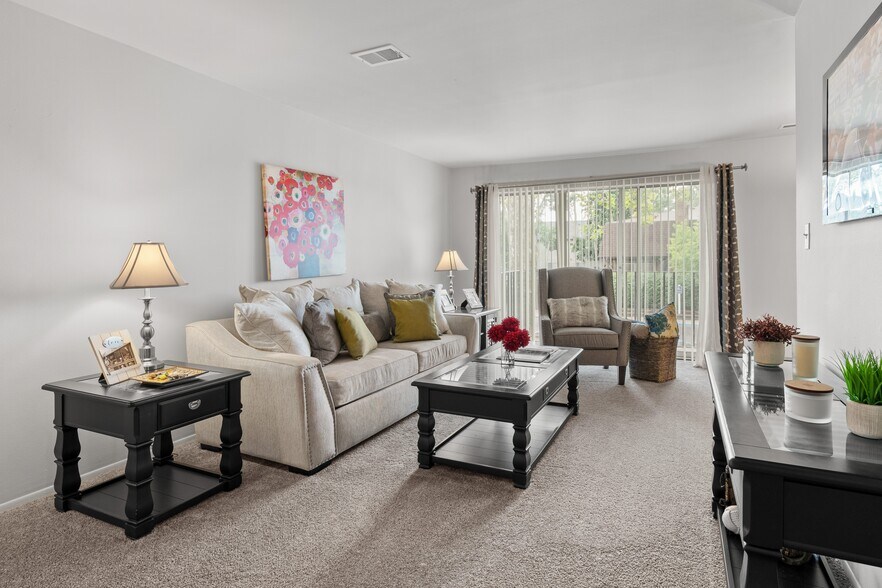 Open and airy living room with natural lighting at Knottingham Apartments in Clinton Township, MI. - Knottingham Apartments