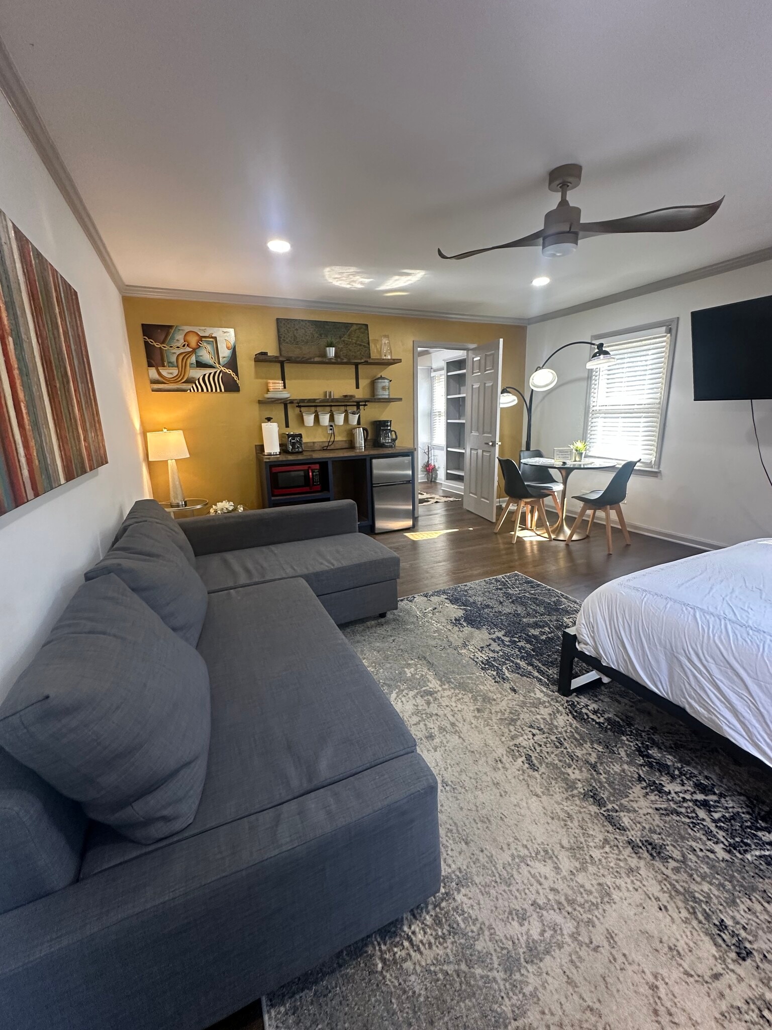 Downstairs bedroom comfort meets convenience — sofa, TV, kitchenette, and perfect for any moment. - 5460 Scofield Rd