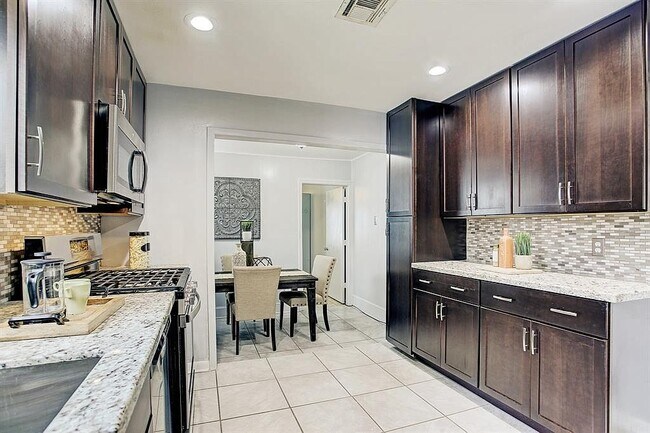 Kitchen with view of dining room and door leading to 3rd bedroom - 1617 Tabor St