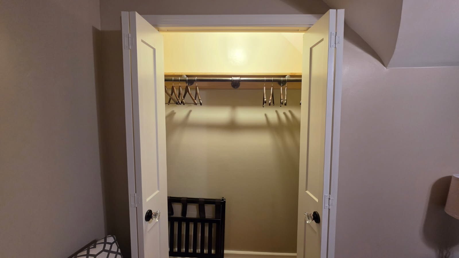 Spacious, well-lit bedroom closet with generous hanging space, hangers, and a folding luggage rack. - 1901 -2301 Fillmore Street NE Minneapolis, MN 55418