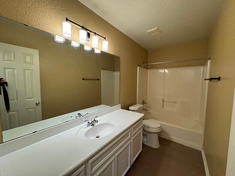 Oversized vanity with new countertop, brilliant lighting, and a sparkling tub/shower combo make busy - 2806 Maria Dr