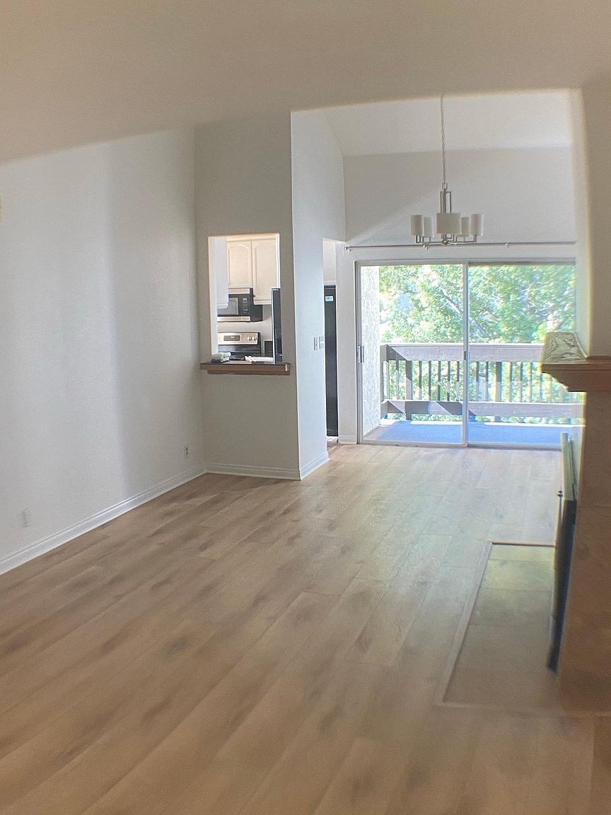 Bright living and dining areas with vaulted ceilings and private balcony - 8305 Summertime Ln