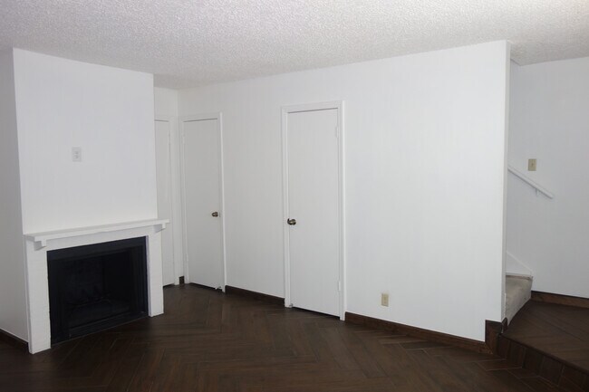 Living room with view of doors to half bath, understairs storage, coat closet (door not visible) - 3421 E 35th St