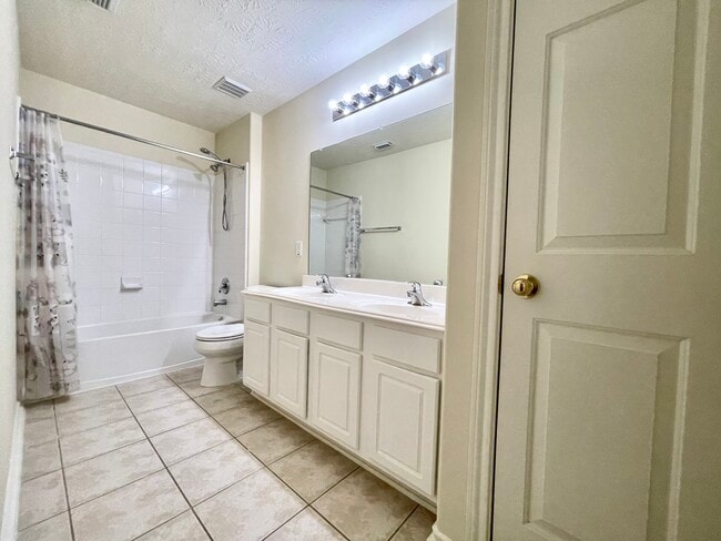 2nd bathroom located on second floor including double sinks, bathtub with shower head, and storage. - 18911 Piney Bend Ct