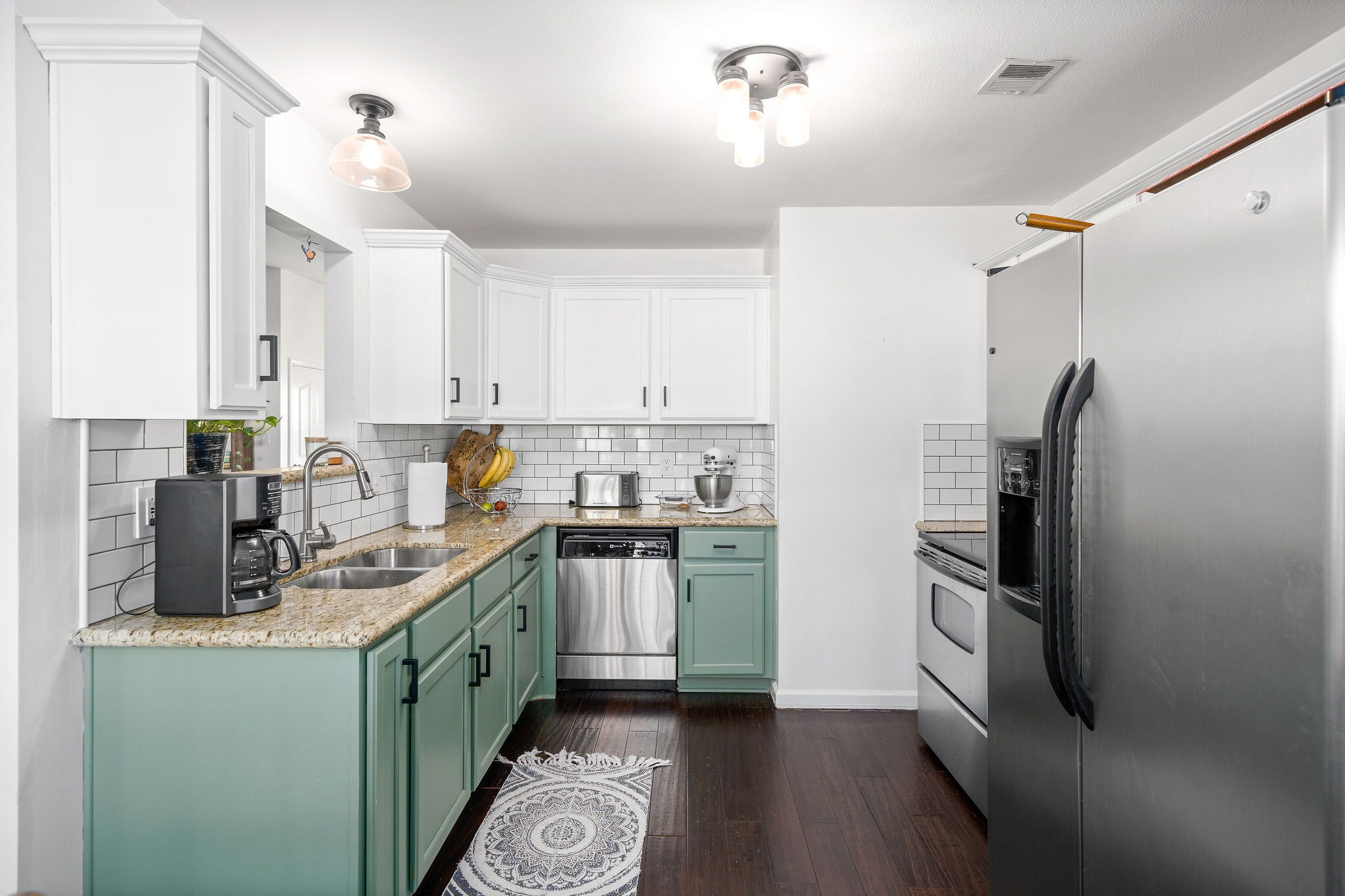 Kitchen with freshly painted two-toned cabinets and new subway tile. - 525 Parkvue Village Way