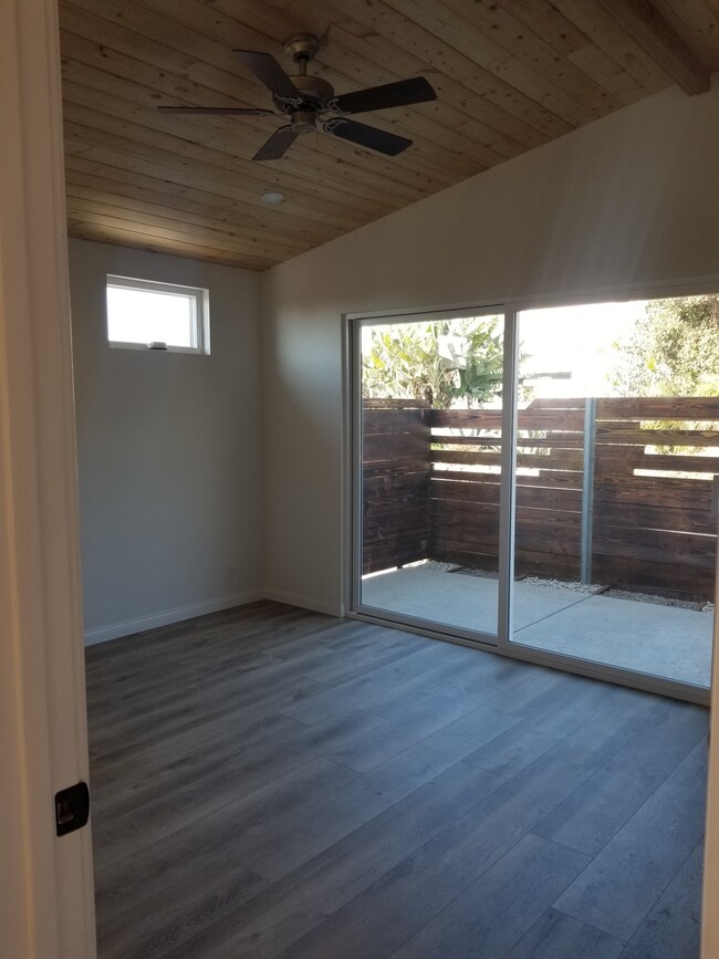 Master bedroom with wood high ceilings, ceiling fan, private courtyard, custom driftwood mantel over - 6832 Zelzah Ave