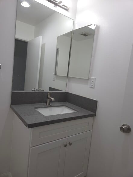 En suite 1/2 bath with quartz countertop and Shaker cabinets - 3455 Elm Ave