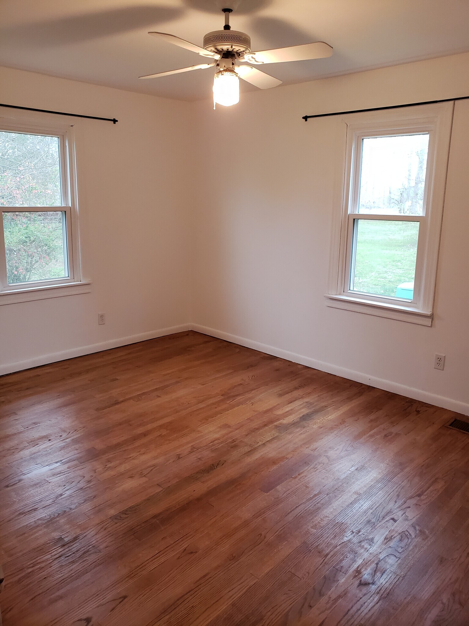 Bedroom at back of house has refinished original hardwood floors and ceiling fan. - 10106 Wingfield Rd