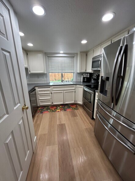 Kitchen with pantry and stainless steel appliances - 10377 W Alliance St