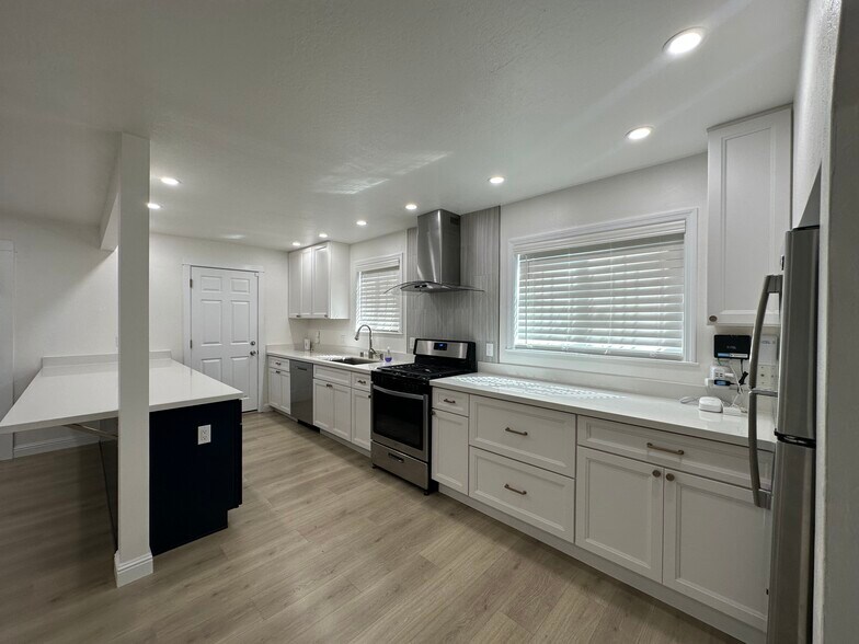 Modern kitchen with quartz countertops, two-tone cabinetry & stainless appliances. - 721 15th St