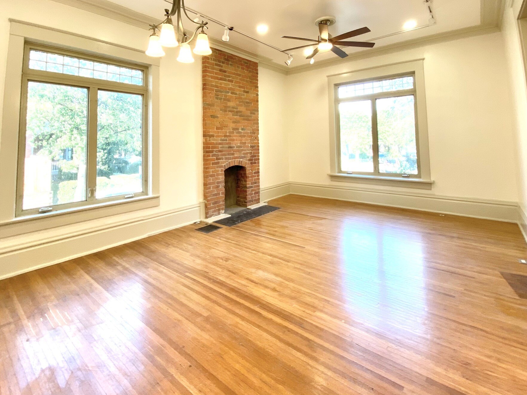Large sun room / living room with original Victorian exposed brick. - 1321 Highland St