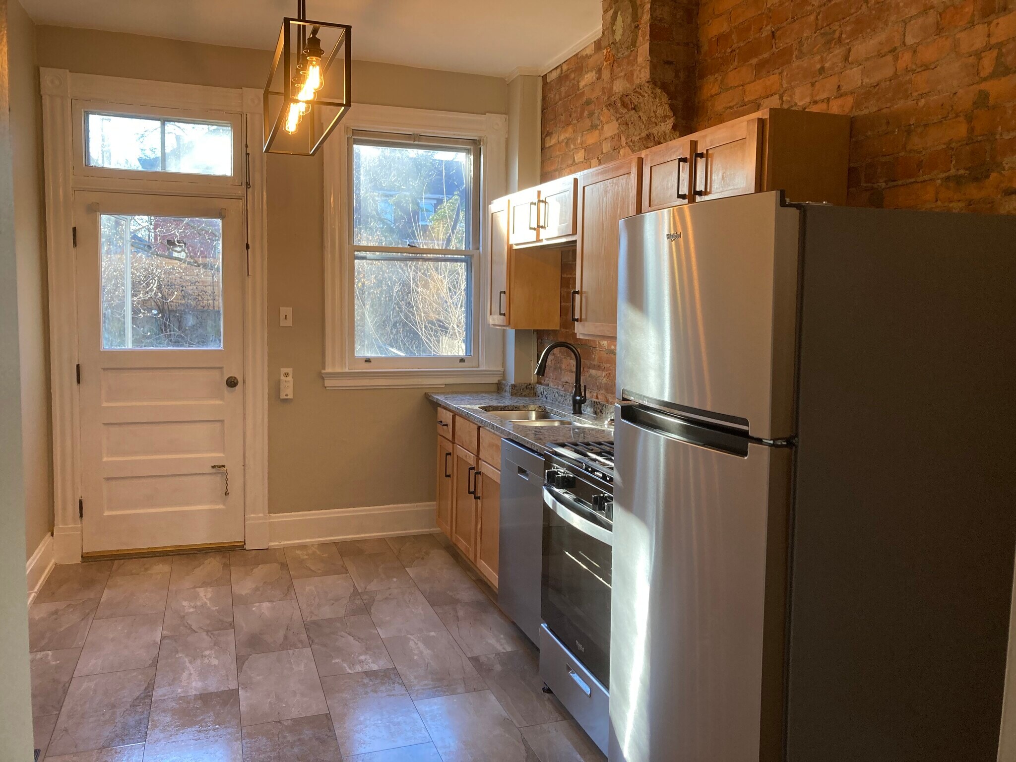 Kitchen has granite countertops and access to the backyard. - 2221 Oakland Ave, Apt A