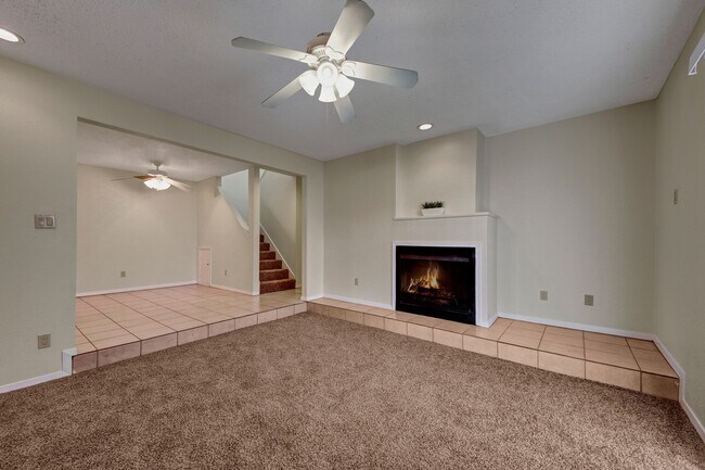 A Living Room With a Ceiling Fan and Fireplace - Las Colinas