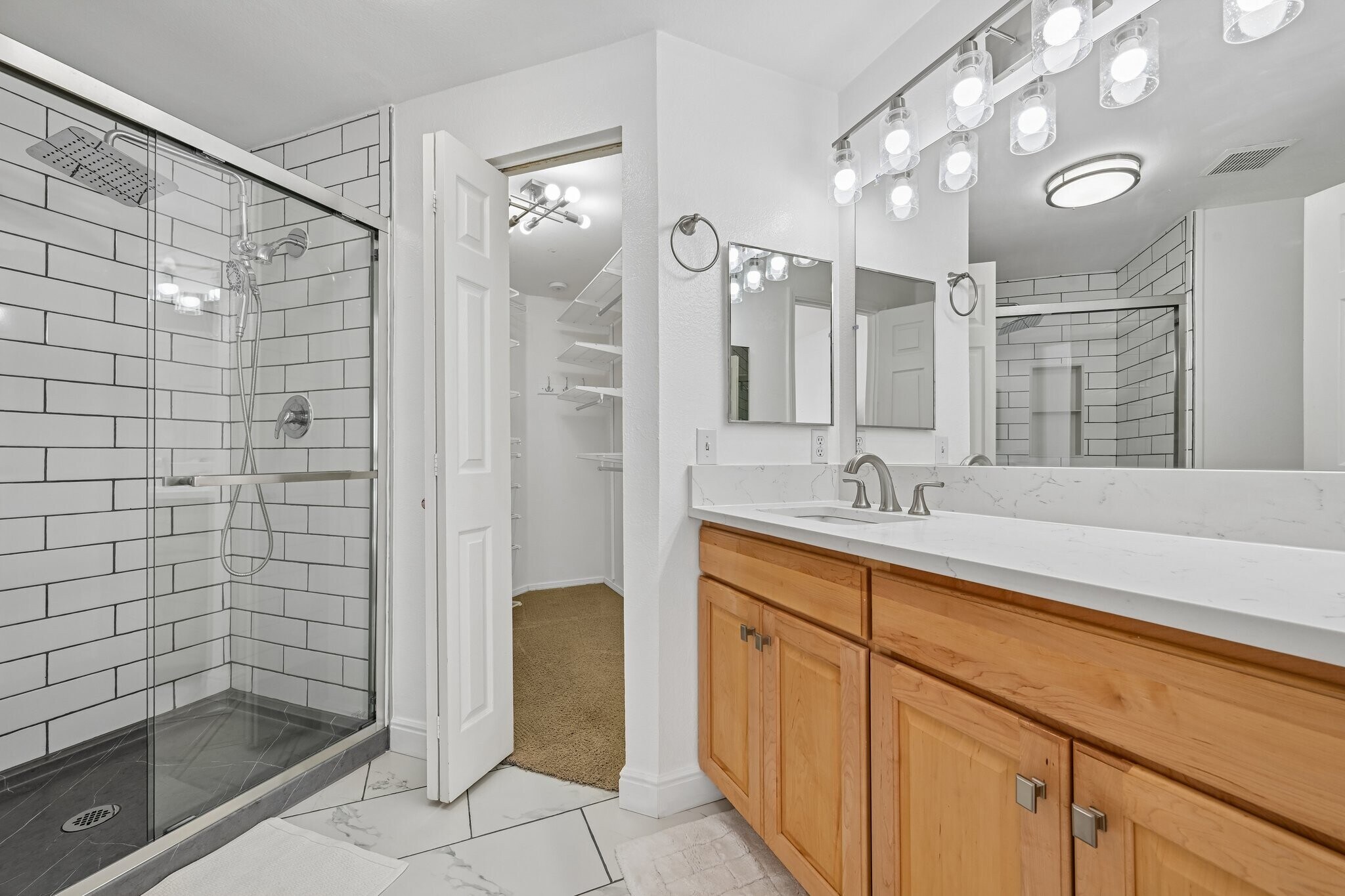 newly remodeled primary bath with rainfall showerhead and quartz countertops - 8747 E Dry Creek Rd