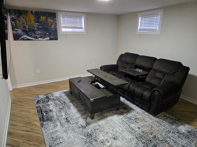 Downstairs living room with adjustable couch and coffee table. - 902 S Zephyr Ct