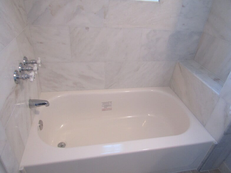 Bathtub with a large, marble ledge for toiletries - 1800 West Abingdon Drive