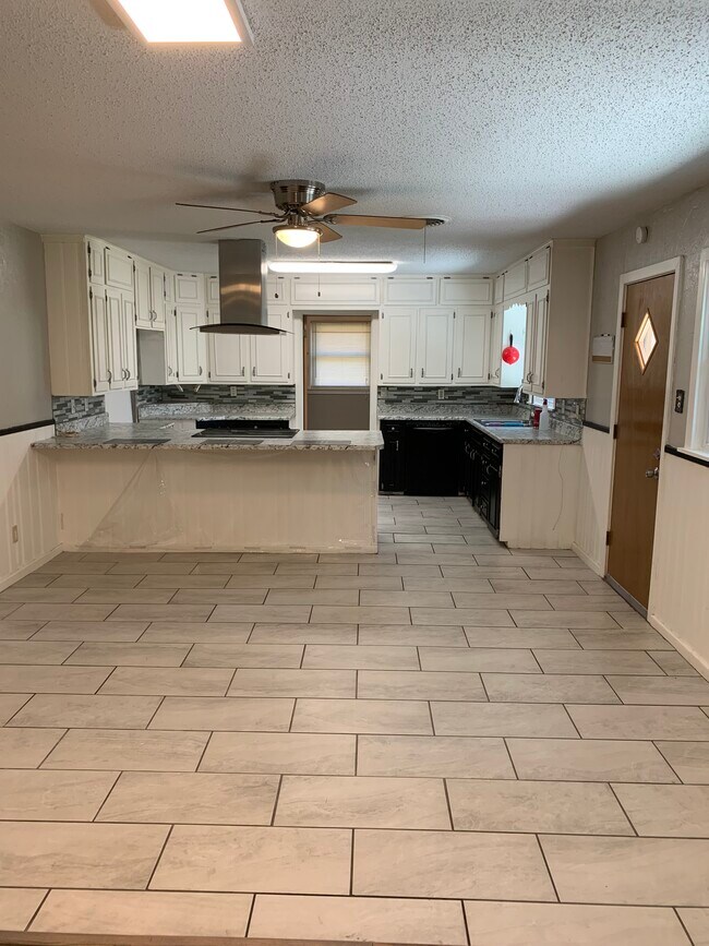 Looking at the kitchen from the opposite end of the second living area that has solid vinyl floors - 4308 Olsen Blvd
