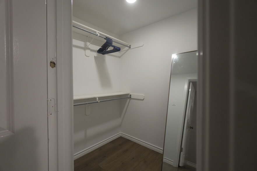 Bedroom 1 features a queen bed and a walk in closet - 2708 Pin Oak Ln