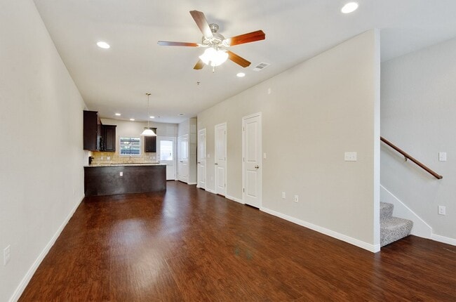 Spacious living area with wood style flooring and ceiling fans - Tinsley Place