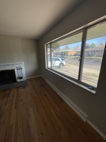 Living room with large window and front and fireplace - 7991 E Hampden Cir