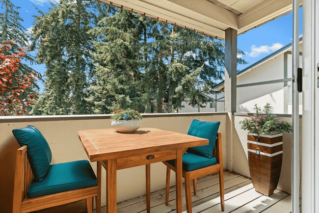 Enjoy peaceful moments on this inviting balcony, perfect for relaxation and nature views. - University Crossing Apartments