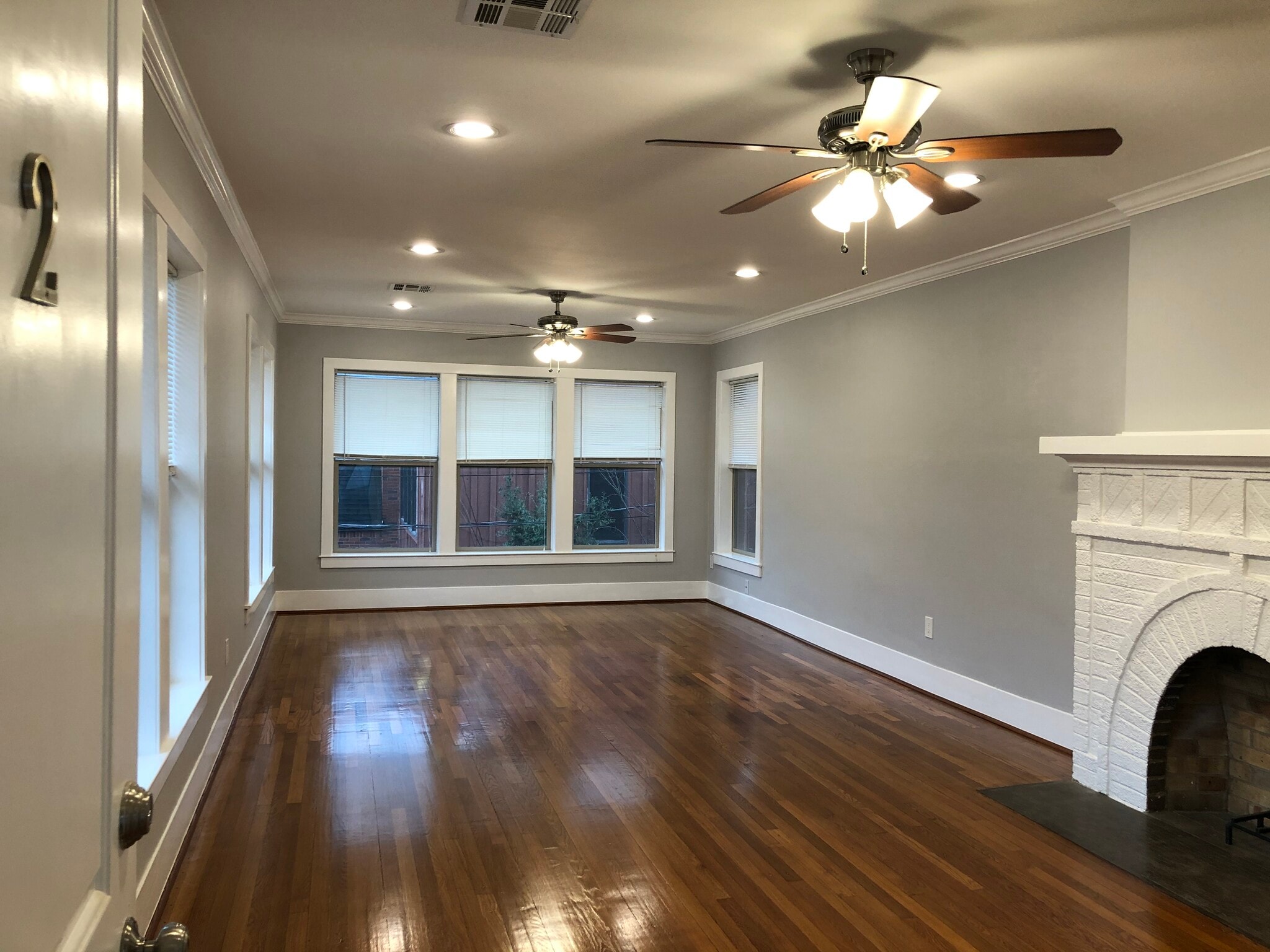 Main living room with beautifully refinished hardwood floors and natural lighting - 1712 Blodgett St