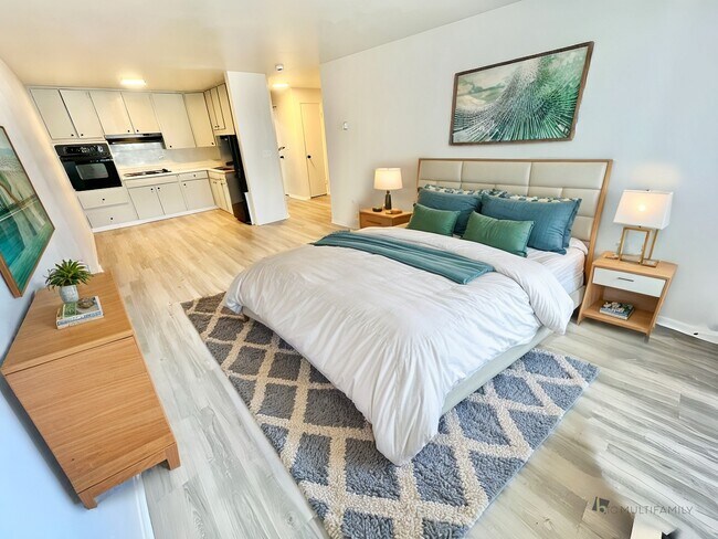 Experience the blend of comfort and style in this beautifully designed bedroom with a modern kitchen view. - The Sloan