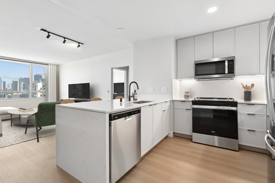 Signature Collection Phase I kitchen and living room with hard surface flooring - Avalon at Mission Bay