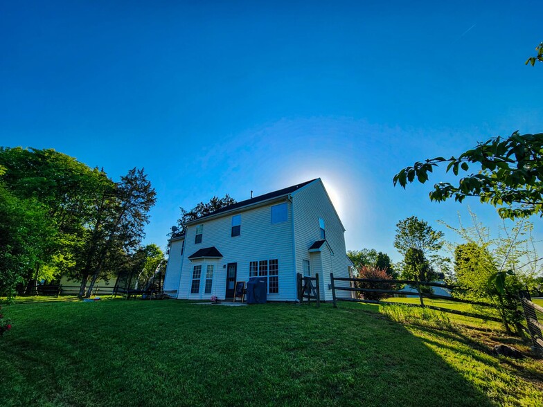 Backyard with green lawn, patio access, and fenced privacy. - 7801 Peach Blossom Ct